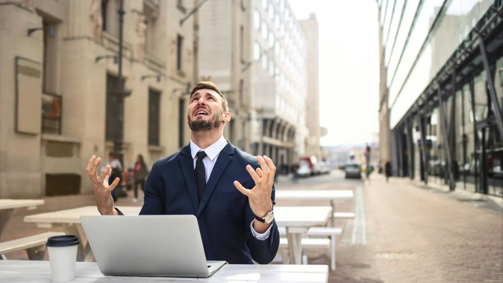 A young worker is angry that his laptop has suddenly stopped working during a lunch meeting.