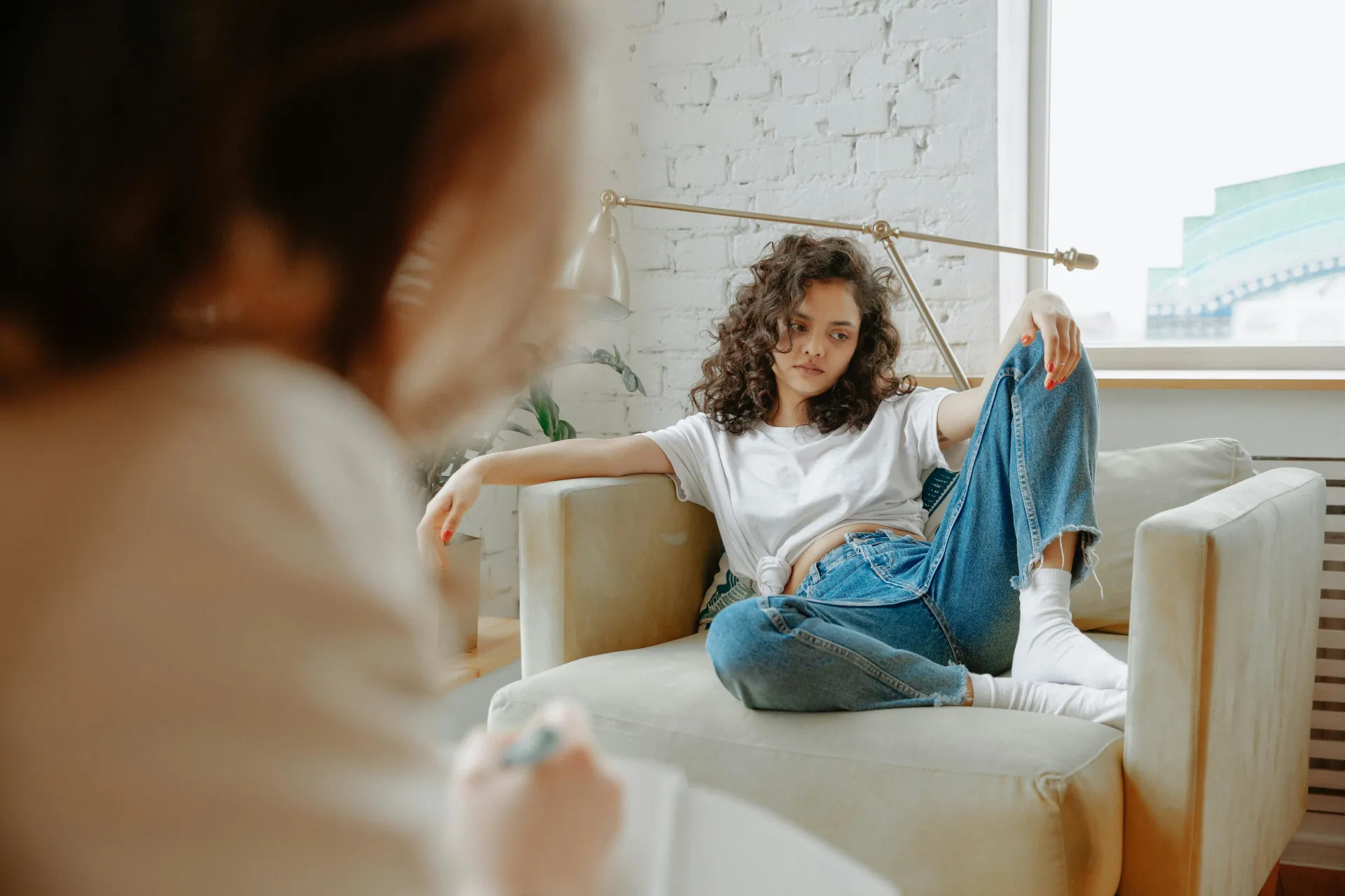 A young female is discussing feelings with a therapist during a Cognitive Behavioural Therapy session.